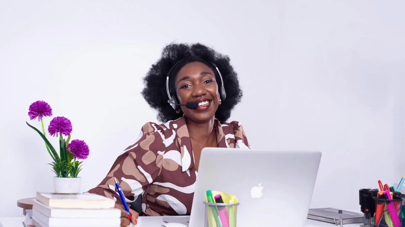 Customer support professional using a VoIP headset and laptop, representing cloud-based business phone system support